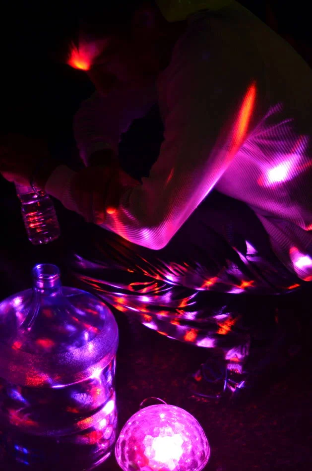 A disco ball under a water bottle, projecting colour onto everything around it. Someone thought about how to make this feel less like charity and more like a party.