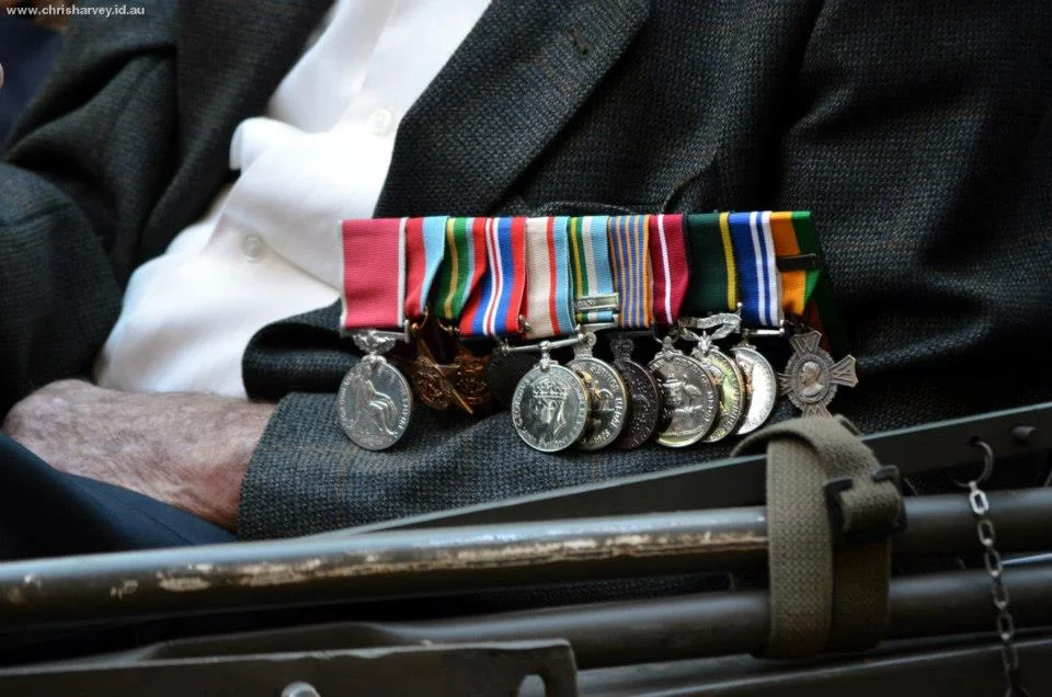 A row of service medals resting on a tweed lapel tells you more about a life than any biography. You just have to be close enough to read it.