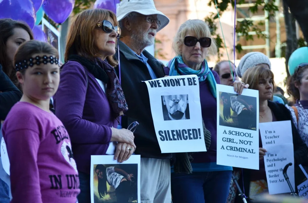 Purple balloons and 'We Won't Be Silenced' signs and a child looking directly at the lens — that combination of colours and faces tells the whole story of the day.