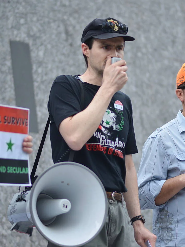 His voice was amplified but his face was not. The megaphone came down between speeches and that was when I made the frame.