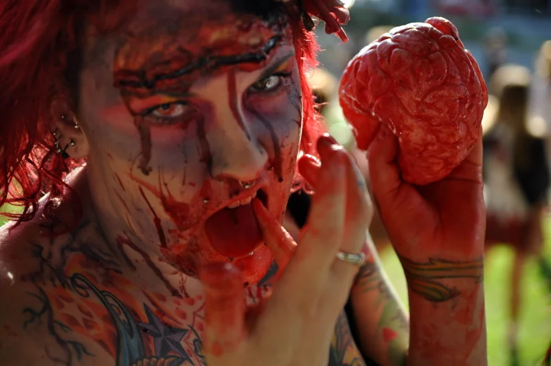 Red hair, red makeup, red everything, and a prosthetic brain held aloft. At a certain level of commitment, the image makes itself.