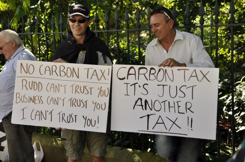 Two men with signs, laughing at something off camera. Political rallies have more laughter in them than photographs usually show.