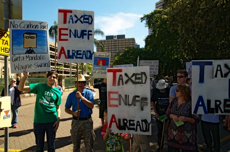 Multiple people carrying identical signs. The coordination is part of the message — and part of the photograph.
