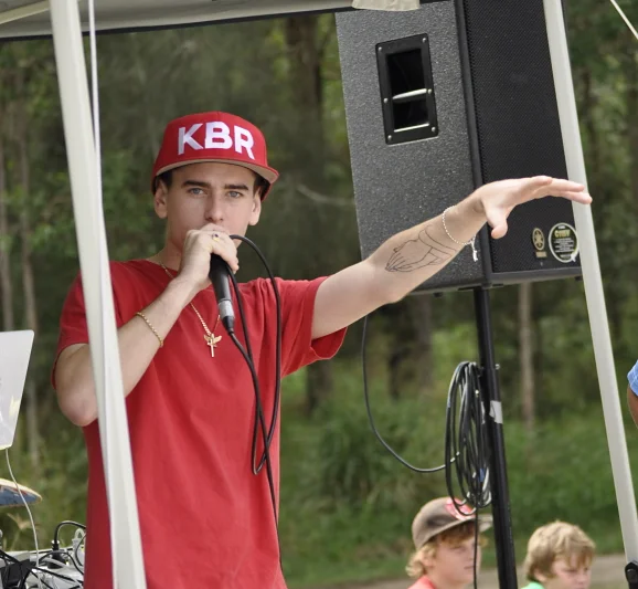 The KBR emcee works the microphone between runs. The event has its own soundtrack.