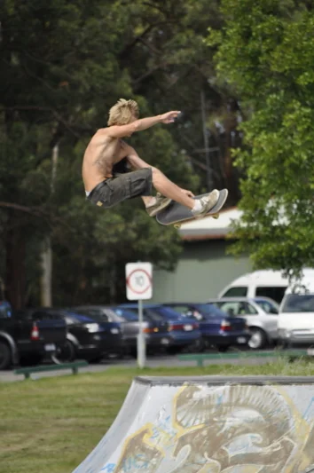 Green trees behind him, board under his feet, everything suspended for a moment between up and down.