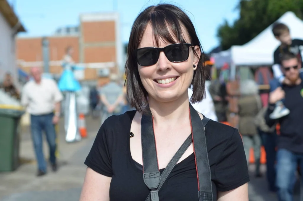 Camera strap, sunglasses, easy smile. Another photographer at the festival, more relaxed than I usually manage to be.