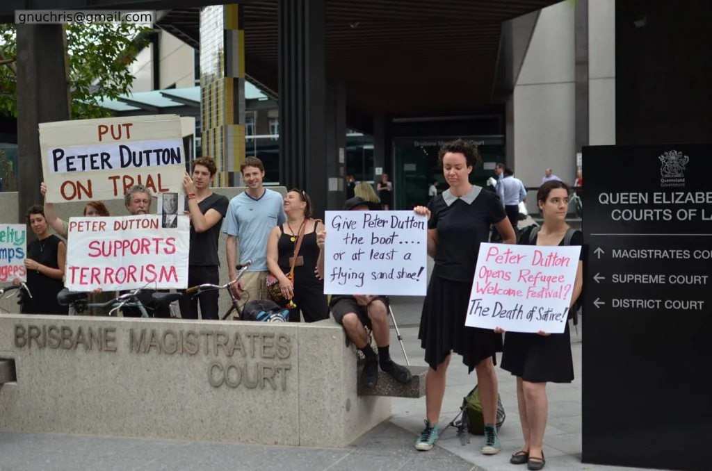 A protest outside a court is its own kind of legal argument — bodies in a public space saying that the official version of events is wrong.
