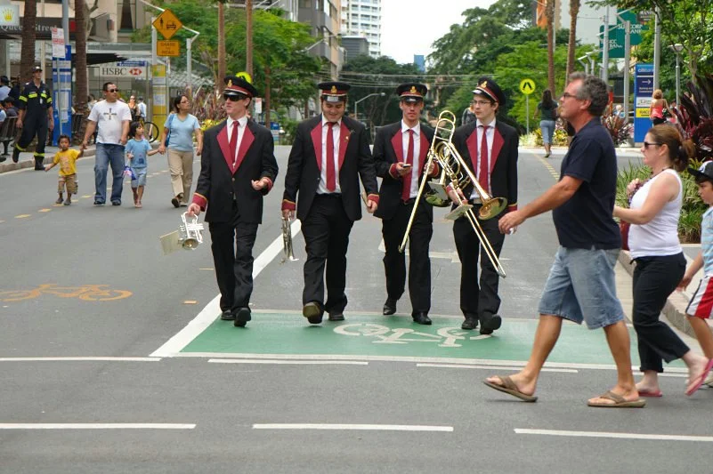 The march is not just the veterans — it is the whole procession, the cadets, the bands, the crowd three deep on the footpath. Tell the whole story.