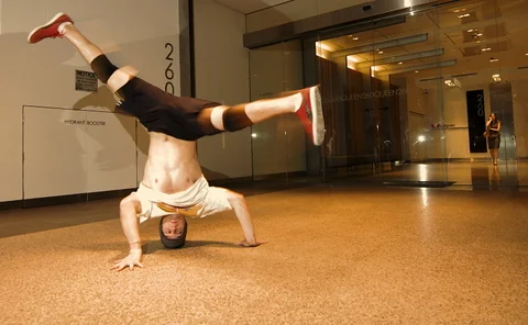 A solo practitioner in an empty building lobby at night is both the subject and the composition. The space around them matters as much as they do.