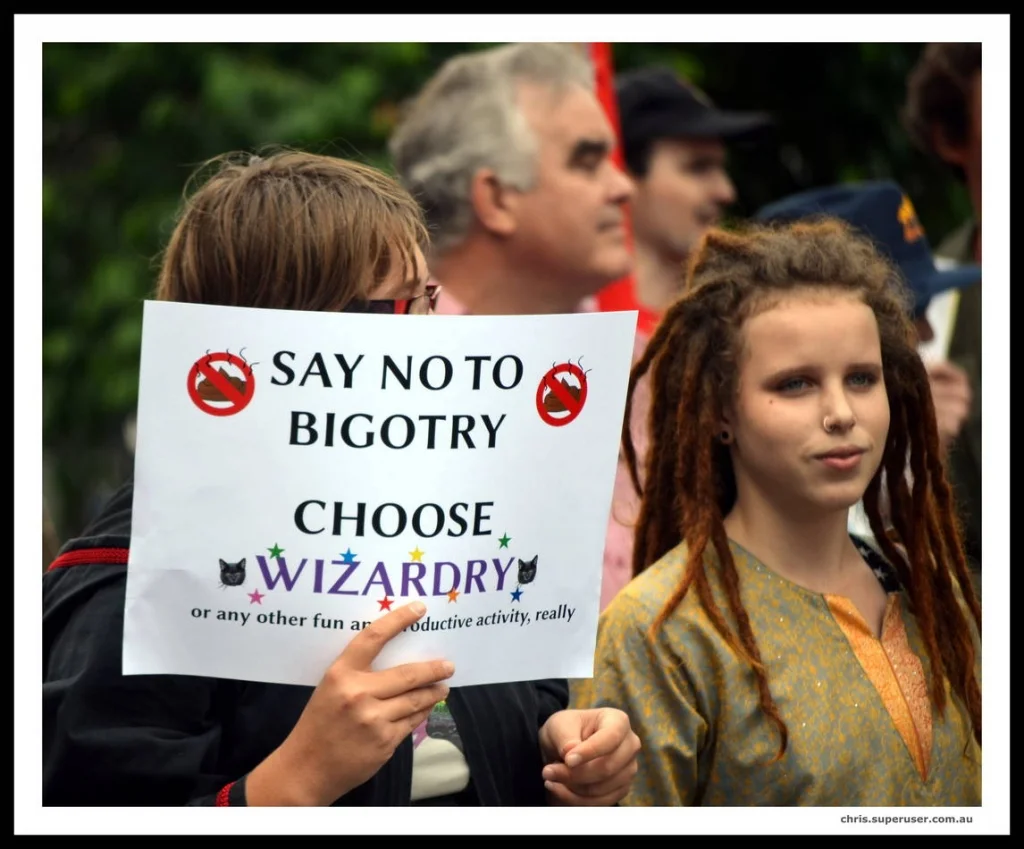 The humorous sign at a serious rally is never just a joke. It is a way of refusing to let the day become only about anger.